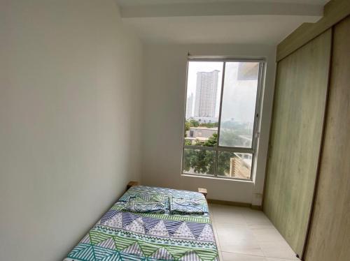 a small bedroom with a bed and a window at Apartamento Playas de Marbella in Cartagena de Indias
