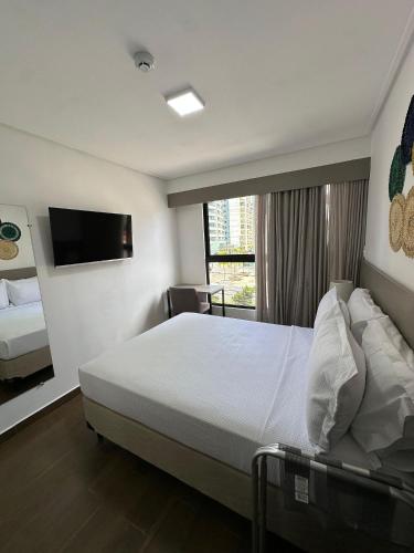 um quarto de hotel com uma cama e uma janela em Move Tambau 108 em Tambaú