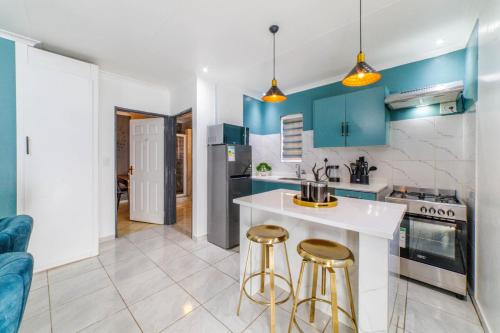 une cuisine avec des placards bleus et un comptoir blanc dans l'établissement Homes of Ace Gold, à Pretoria