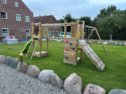 a wooden playground with a ladder and a slide at Linnebarg Hus 1 in Bisdorf