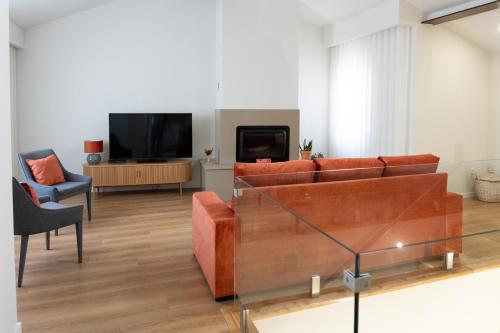 a living room with a couch and a tv at Casa Flavius Montalegre in Montalegre