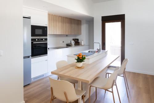 a kitchen and dining room with a wooden table and chairs at Casa Flavius Montalegre in Montalegre