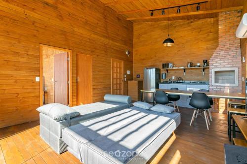 a living room with a couch and a kitchen at Cabana com vista Serra Catarinense VST023 in São Paulo dos Pinhais