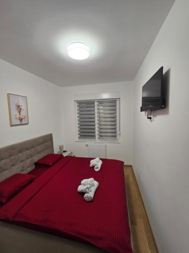 une chambre avec un lit rouge avec des serviettes dessus dans l'établissement Dana, à Banja Luka