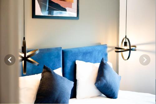 Bett mit blauem Kopfteil und 2 Kissen in der Unterkunft The Aurelia Apartments VII - 1 Bed Apartment in Peterborough