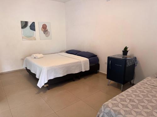 a small bedroom with two beds and a table at Chalé com Varanda Grande e Terraço Vista Mar in Itanhaém