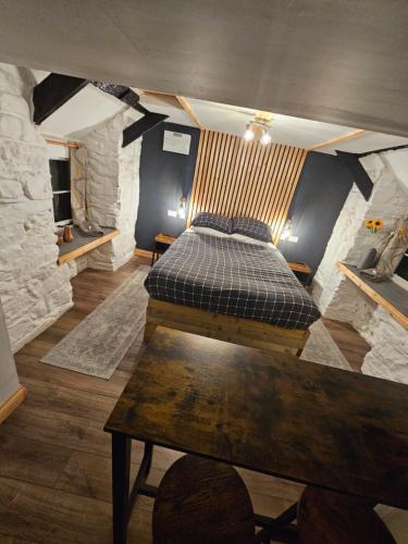 ein Schlafzimmer mit einem Bett und einem Holztisch in der Unterkunft Romantic Hideaway in Trawsfynydd