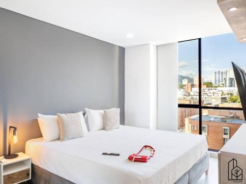 une chambre avec un lit blanc avec un téléphone rouge dessus dans l'établissement Bizsar Ocobo Aire Acondicionado Exclusivo 2 Piscinas, à Vallecito