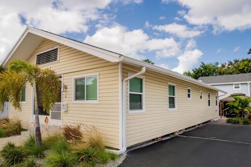 a small yellow house with a garage at Cozy Coastal Cottages of Dunedin 1 in Dunedin