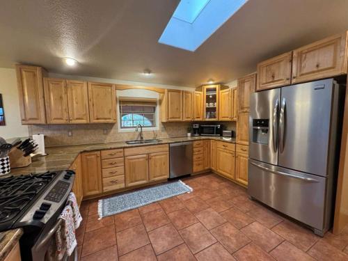 a kitchen with wooden cabinets and a stainless steel refrigerator at White Sands NP Retreat in Alamogordo