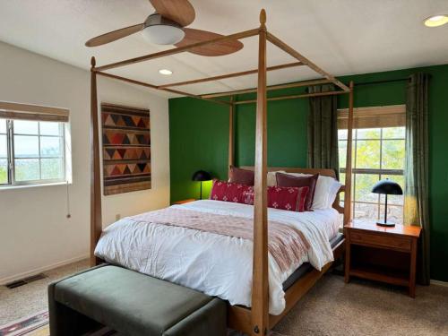 a bedroom with a canopy bed and green walls at White Sands NP Retreat in Alamogordo