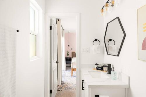 斯科茨Blush Bungalow的一间白色浴室，配有洗手池和镜子。