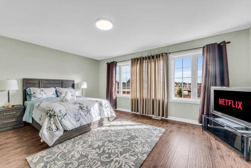 a bedroom with a bed and a tv at Luxury Mansion with Chefs Kitchen by Niagara Falls in Thorold