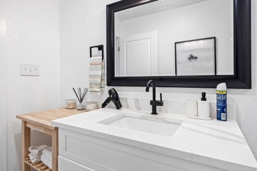 een wastafel in de badkamer met een grote spiegel erboven bij Cozy Modern 1BR Casita - Near Lackland & SeaWorld in San Antonio