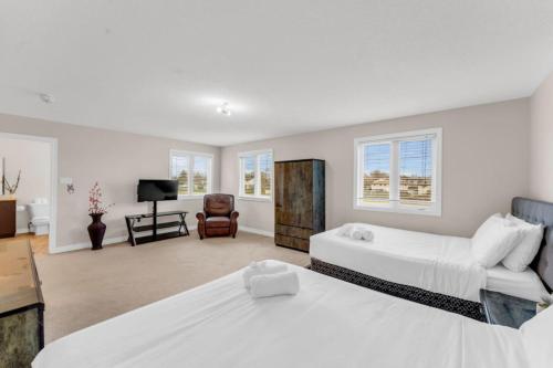 a large bedroom with two beds and a television at Luxury Home Mins from Waterfall next to Transit in Niagara Falls