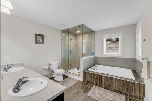 ein Badezimmer mit Badewanne, Waschbecken und Toilette in der Unterkunft Bright and Stylish Family Home Near Niagara Falls in Thorold