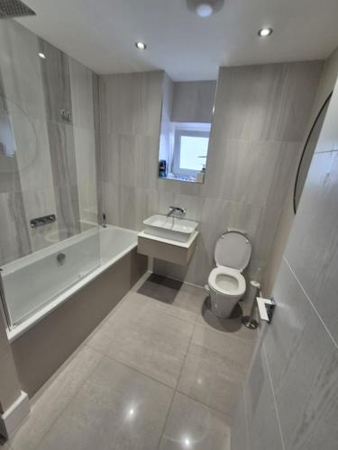 a bathroom with a tub and a toilet and a sink at Ardlui House Gardens in Hamilton
