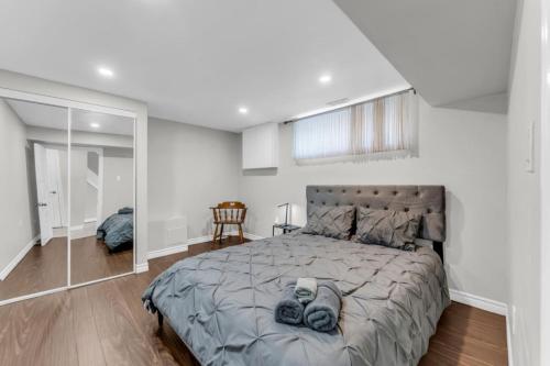 Un dormitorio con una cama grande y un espejo. en Spacious 6BR Getaway Sleeps 16 Yard and Parking, en Brampton
