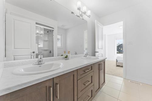 a bathroom with two sinks and a large mirror at Luxury New Home By Niagara Fall in Fonthill
