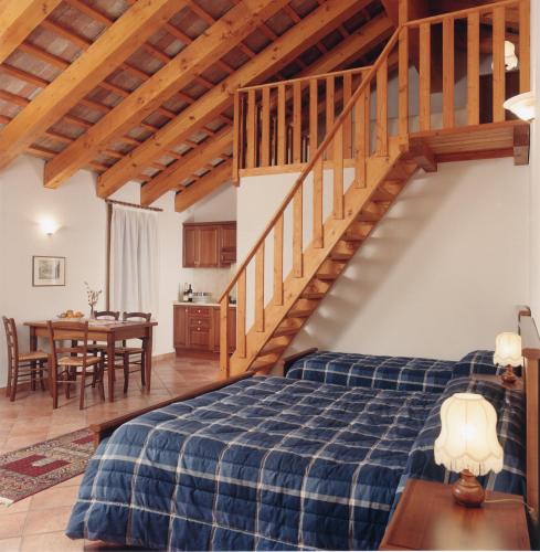 a bedroom with a bed and a wooden staircase at Il Castagneto in Teolo