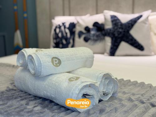 a pile of rolled up towels on a bed at Emunah Di Città Flats Ponta de Campina in Cabedelo