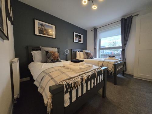 een slaapkamer met twee bedden en een raam bij Modern Stirling Apartment - Free Parking in Stirling