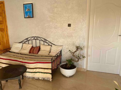 a bedroom with a bed and a chair and a plant at Apartment Private room in apartment in Khouribga in Khouribga