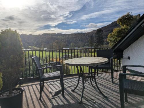 a patio with a table and chairs on a balcony at Lake View Country House and Self-catering Apartments in Grasmere