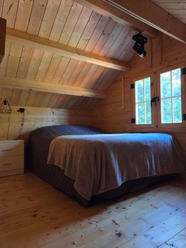 Saint-OnésimeにあるLa Taniere du Renardの丸太小屋のベッドのある寝室