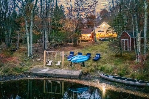 a boat sitting on a dock next to a lake at Long Pond Lakeside Kayaks Hot Tub Playground in Emerald Lakes