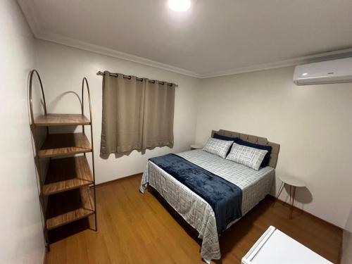 a bedroom with a bed and a book shelf at Pousada Rota do Vale in Pomerode