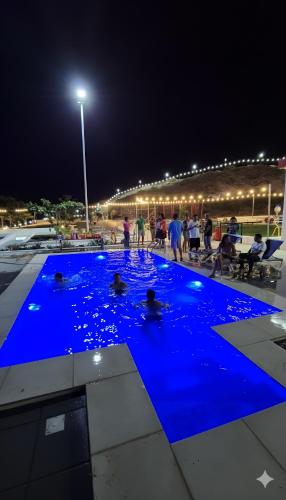 Menschen in einem Pool mit blauem Wasser bei Nacht in der Unterkunft Farmhouse-Villa--فيلا-المزرعة in Hatta