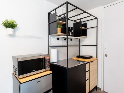 a room with a desk with a tv and a shelf at AQUA Terrazas Studio 5 - Oceanfront, Pool & Local Dining in Mameyal