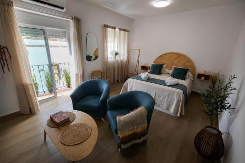 una camera da letto con un letto, due sedie e un tavolo di La Zarzamora a Jerez de la Frontera