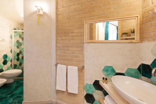 a bathroom with a sink and a toilet and a mirror at Agriturismo La Collina in Pitigliano