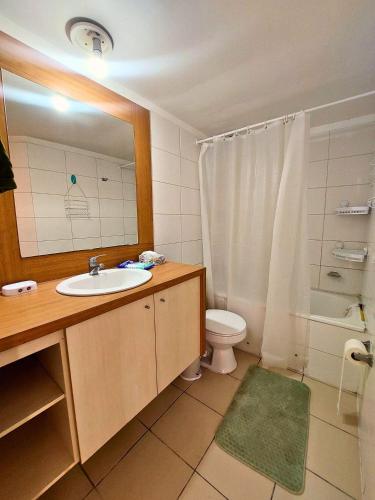 a bathroom with a sink and a toilet and a mirror at Viña Sunset Escape in Viña del Mar