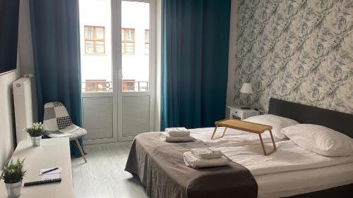 a bedroom with a bed with a table and a window at Apartamenty Szlachecki i Pod Artusem in Gdańsk