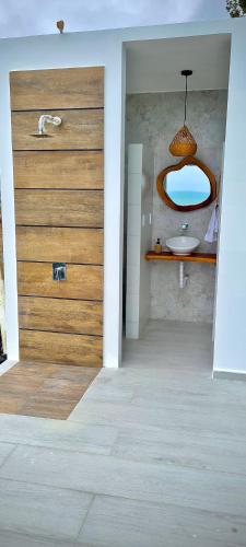ein Badezimmer mit Holztür und Waschbecken in der Unterkunft Refugio Sova in Jama