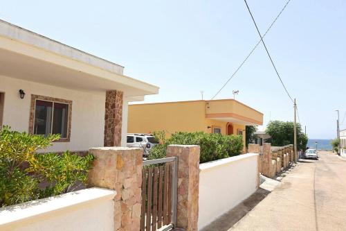 una casa con una recinzione di fronte a una strada di Casa Vacanze Mareblù ad Alliste