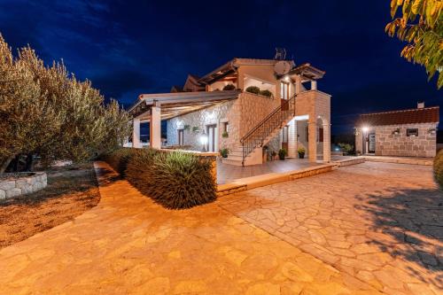 a house with a stone driveway in front of it at My Dalmatia - Villa Marijana in Radonić