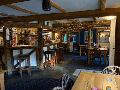 a restaurant with wooden tables and chairs and a bar at The Black Horse Inn in Dursley