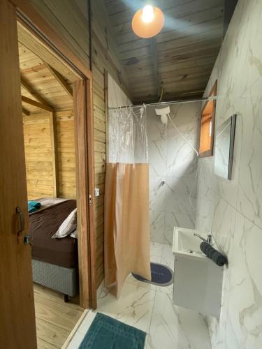 a bathroom with a shower and a bed and a sink at Floripa Glamping in Florianópolis