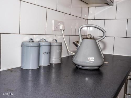 a tea kettle on a counter with three trash cans at En-suite 6 Woodhouse, private bath, 2 kitchen in Stoke on Trent
