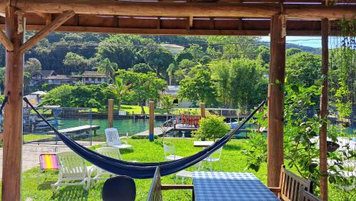 a hammock on a patio with a view of the water at Floripa Glamping in Florianópolis