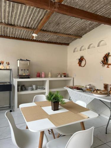 een eetkamer met een tafel en stoelen en een keuken bij Vilacessivel Pousada in Porto De Galinhas