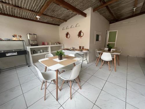 een kamer met een tafel en stoelen en een keuken bij Vilacessivel Pousada in Porto De Galinhas