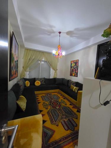 ein Wohnzimmer mit einer Couch und einem Kronleuchter in der Unterkunft Fade House in Temara