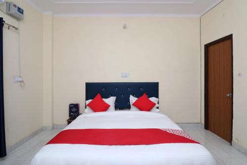 a bedroom with a large bed with red pillows at Hotel O JAGPAL STAY in Gurgaon