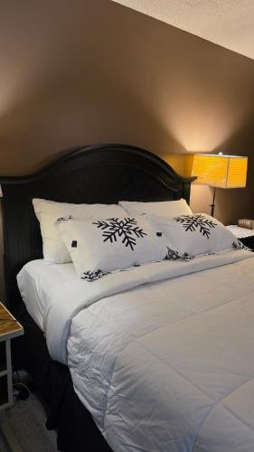 une chambre avec un grand lit avec des draps et des oreillers blancs dans l'établissement Master bedroom in a quiet and smoke-free home, à Winnipeg