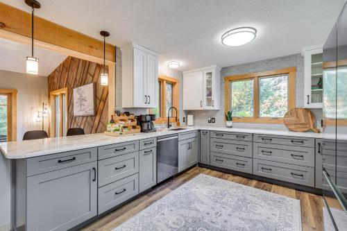 a kitchen with white cabinets and white counter tops at Riverbend Retreat on 7 Acres with River Access! in Webster